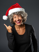Old Woman In Santa Hat Points At You On Dark Isolated Background
