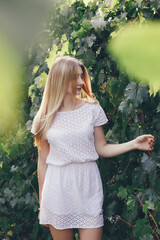 Beautiful young adult woman in the sunlight of sunset. Beautiful woman is enjoying warm and sunlight in park. 