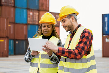 Wall Mural - Industrial workers using computer tablet for container shipping control at warehouse storage outdoor - Delivery site concept - Focus on senior African woman face