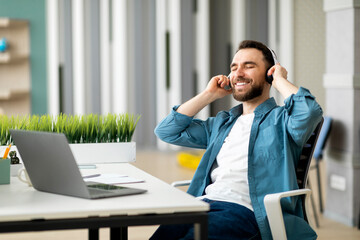 Aufkleber - Break At Work. Young businessman listening to music at workplace in office