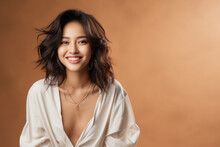 Pretty Young Asian Woman Smiling Looking At Camera On Plain Background.
