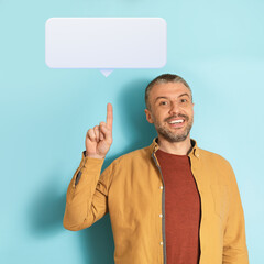 Poster - Positive middle aged caucasian man pointing up at speech balloon