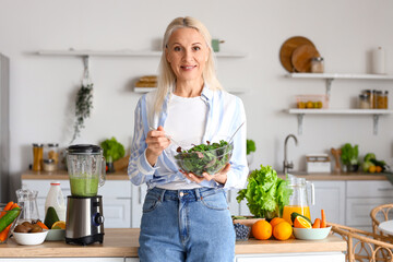 Poster - Mature woman with bowl of vegetable salad in kitchen