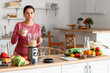 © Pixel-Shot - Sporty young woman pouring milk into blender in kitchen
