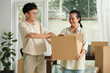 © DragonImages - Cheerful family packing belongings in cardboard boxes