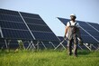 © Serhii - African American engineer maintaining solar cell panels. Technician working outdoor on ecological solar farm construction. Renewable clean energy technology concept