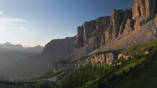Fly Over Beautiful Mountain Views In The Morning Sunrise. View Of The Orange Rocky Mountains And The Green Mountain Ridge. Dolomites, Italy
