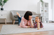 © Sofiia Shunkina - Mother with daughter playing wooden blocks on floor