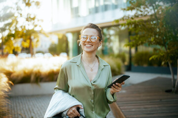 happy modern woman worker in green blouse and eyeglasses