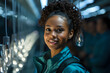 © Yuliia - a young african american woman works in a high-tech production, a young specialist successfully works in a laboratory, a portrait at work of a woman innovator, researcher, technologist