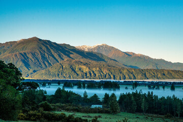 Wall Mural - Early morning fog and mist in the rural valley  of the West Coast at sunrise