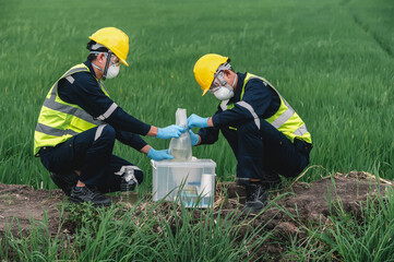 Two Environmental Engineers Take Water Samples at Natural Water Sources Near Farmland Maybe Contaminated by Toxic Waste or Suspicious Pollution Sites