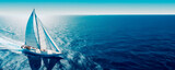 Regatta of sailing ships with white sails on the high seas. Aerial view of a sailboat in a windy state.