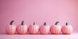 Pink pumpkins in a row on pastel background