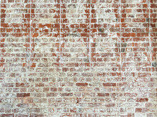 Distressed Red Brick Wall With Remnants Of White Paint That Had Peeled Off Over An Extended Period Of Time.