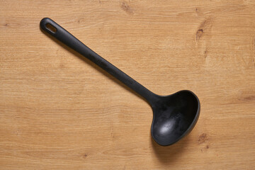 Wall Mural - A black plastic soup ladle