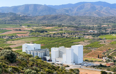 Wall Mural - Grain storage in farm field. Wheat flour plant in Spain mountains. Silo at Agricultural farm. Wheat flour production. Elevator corn storage. Feed Silos Hopper, wheat storage, barley. Rural landscape.