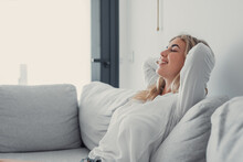 Young Calm Woman Chilling Relaxing Leaning On Comfortable Sofa Napping On Couch In Living Room Resting Having Healthy Quiet Nap, Breathing Fresh Air, No Stress Free Weekend At Home, Peace Of Mind.