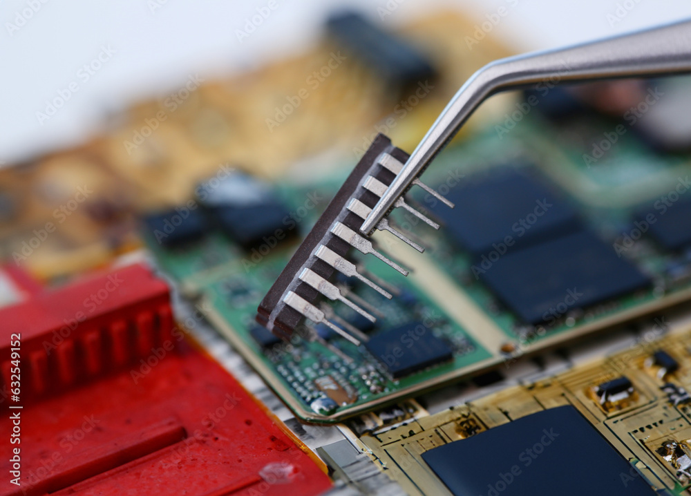 Processor Soldering An employee of computer repair service assembly keeps spare part ...