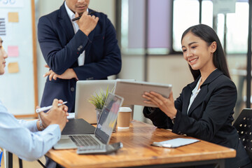 Wall Mural - Business woman present strategy plan on tablet to corporate colleagues in the office