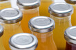 Szklane butelki ze srebrnymi nakrętkami z sokiem pomarańczowym 