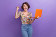 © deagreez - Photo portrait of pretty young girl raise fist orange netbook wear trendy flower print outfit isolated on violet color background