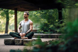 Fototapeta  - Young muscular man sitting and meditating outside in the nature