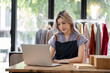 © wichayada - Portrait of a Asian start-up business owner, looking at camera, working happily with cardboard boxes at home, preparing to ship clothes in sme