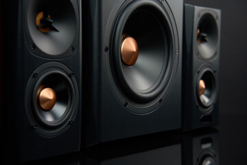 Sound audio system with two satellites and subwoofer on dark background.