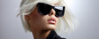 Close-up portrait of a girl with short white hair wearing sunglasses on a white background