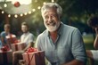 Proud father or grandfather with gift box and kids on blurry natural background, outdoor