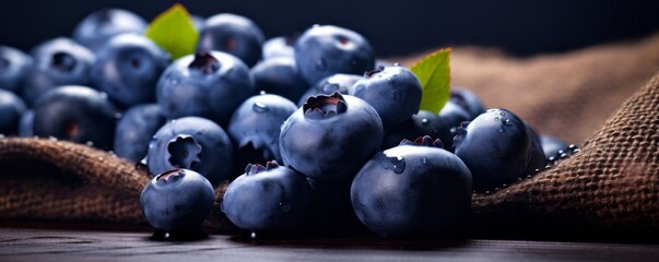 Canvas Print - Freshly picked blueberries in wooden bowl. Juicy and fresh blueberries with green leaves on rustic table. Bilberry on wooden Background. AI generative.