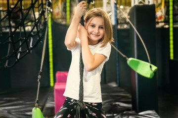 Wall Mural - Cute little girl in rope Park, looking into camera