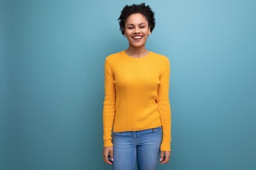 charming young 25 year old hispanic lady with an afro tail is dressed in a casual bright yellow sweater