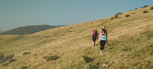 Hiking tour group of friends on mountain peaks