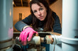 © Lubo Ivanko - Woman plumber working near metal pipes indoor, female professional occupation. Generative AI