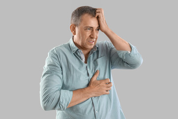 Poster - Mature man having panic attack on light background