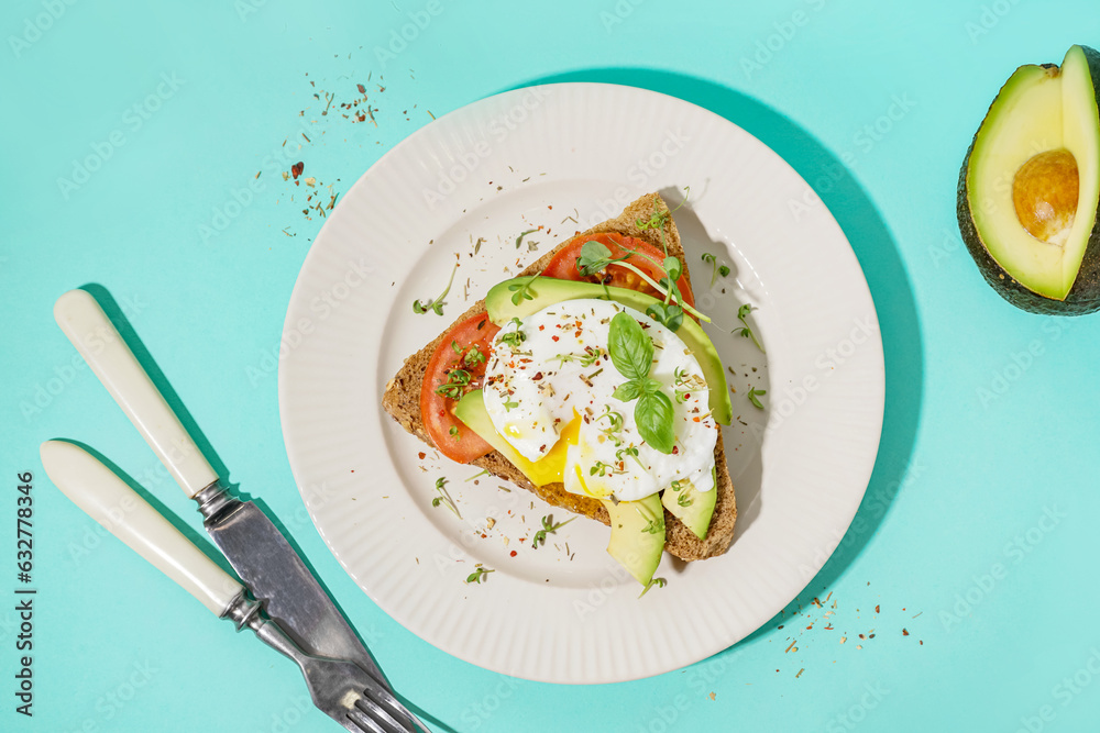 Plate of tasty sandwich with egg on blue background