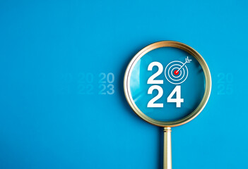 Happy new year 2024 with business concept banner. The big white 2024 year number with Target icon inside the golden magnifying glass on light blue background. Planning for goal and success concepts.