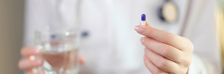 Sticker - Female doctor holds one medical pill in her hand close-up.