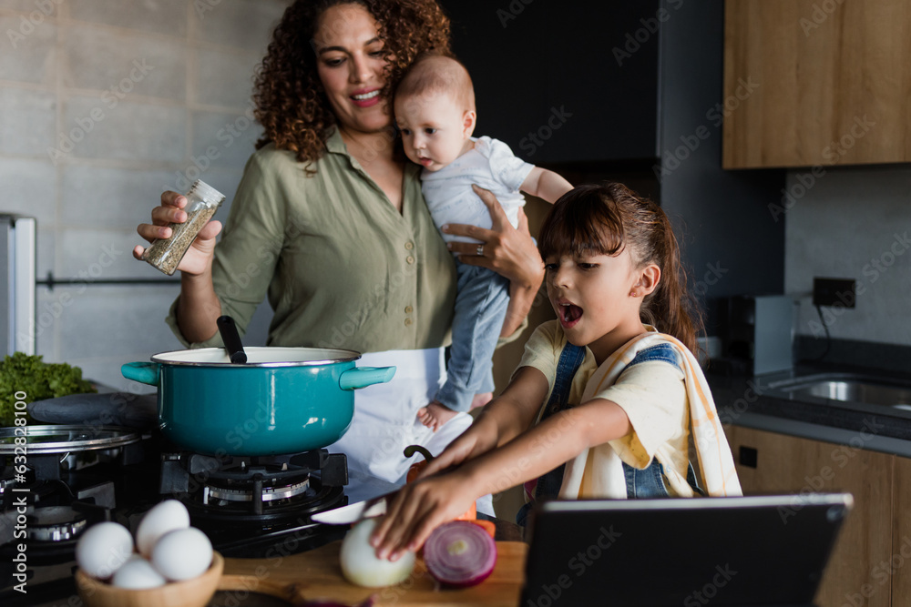 Latin single mother cooking with child daughter and baby at kitchen in Mexico Latin America, hispanic family