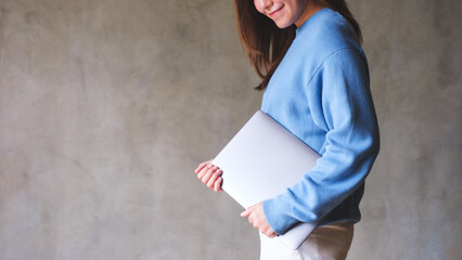 Poster - Closeup image of a young woman holding laptop computer