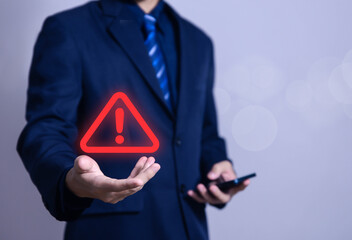 Wall Mural - businessman using laptop showing warning triangle and exclamation sign icon warning of dangerous pro