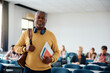 © Drazen - Smiling black senior man attending class in lecture hall and looking at camera.