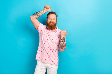 Photo of handsome satisfied man two arms above hand thumb direct empty space poster isolated on blue color background