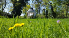  A Gazebo Sitting In The Middle Of A Lush Green Field