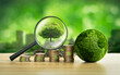 © Wanan - Tree in magnifying glass and green globe green business ideas Finance and Investment for Sustainability and Carbon Credits
