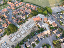 Aerial View Looking On An Area Of New Build Housing Construction On The Edge Of Existing Houses And Green Fields