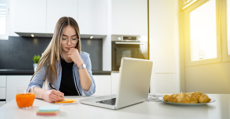 Wall Mural - Female teenage student doing homework at home.