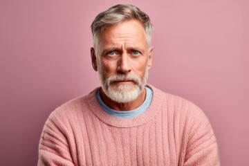 Medium shot portrait photography of a man in his 50s with a hint of fatigue due to chronic kidney disease wearing a cozy sweater against a pastel or soft colors background 